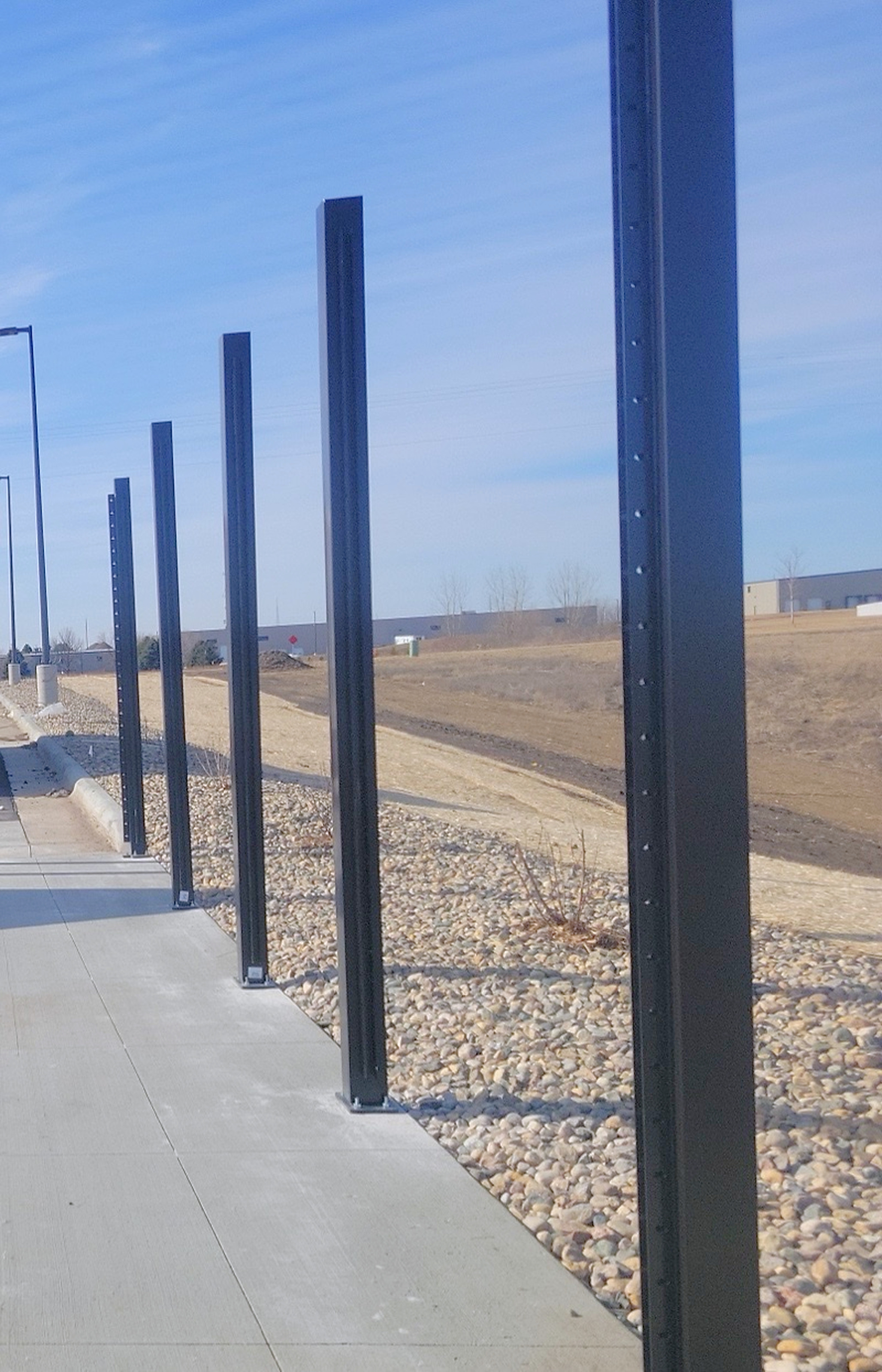 Structural steel posts set on base plates on day one of an enclosure install
