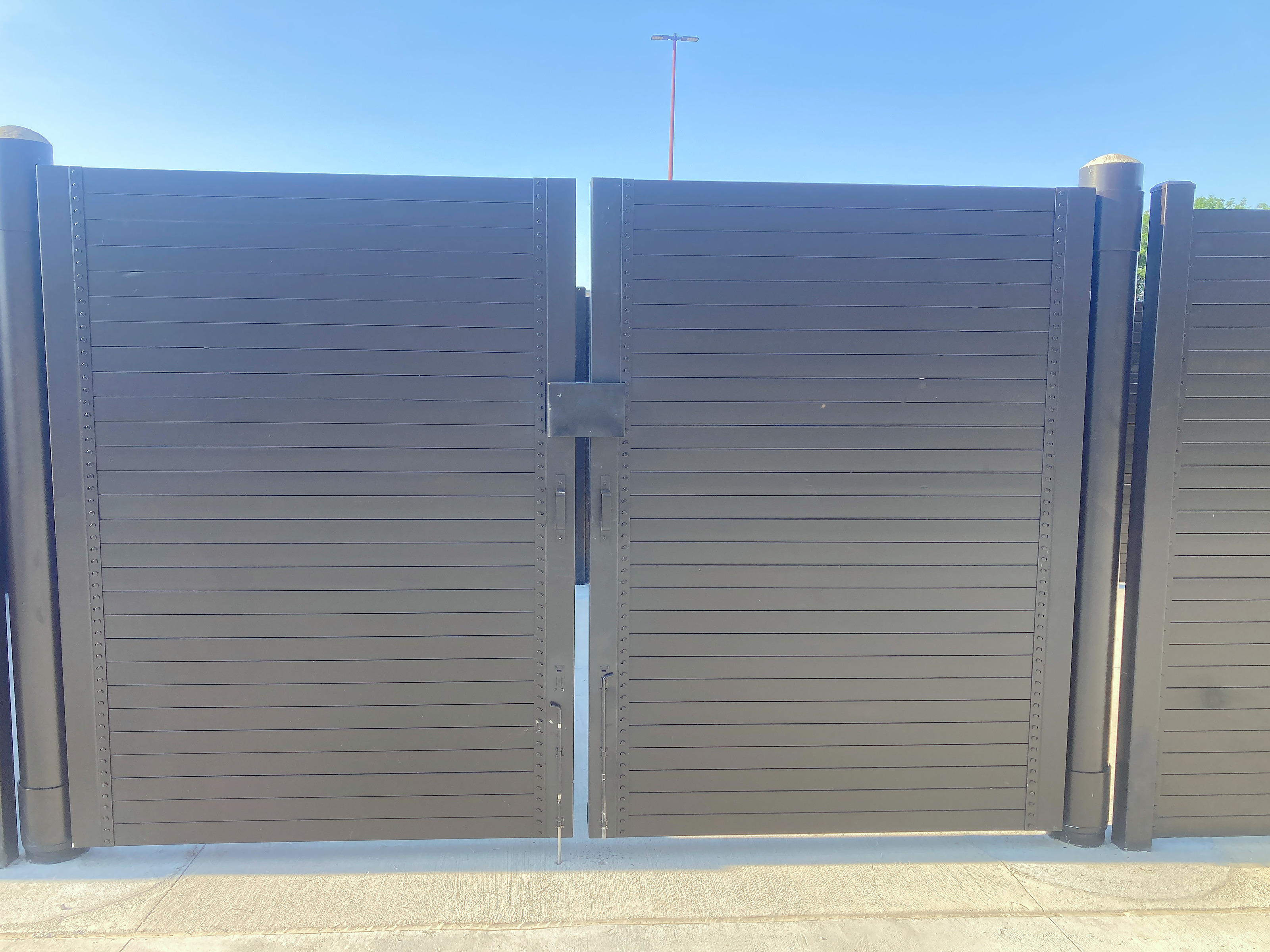 12 ft clear double-leaf steel gate with lockable latch box