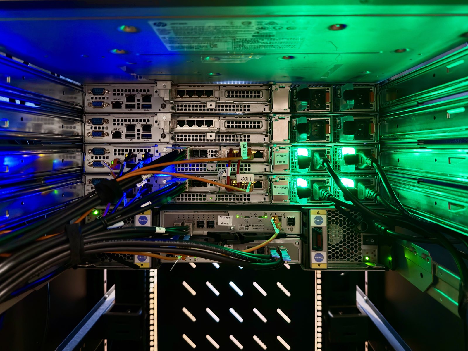 Rear of a SiteLink server rack with primary and secondary servers and storage array lit in blue and green
