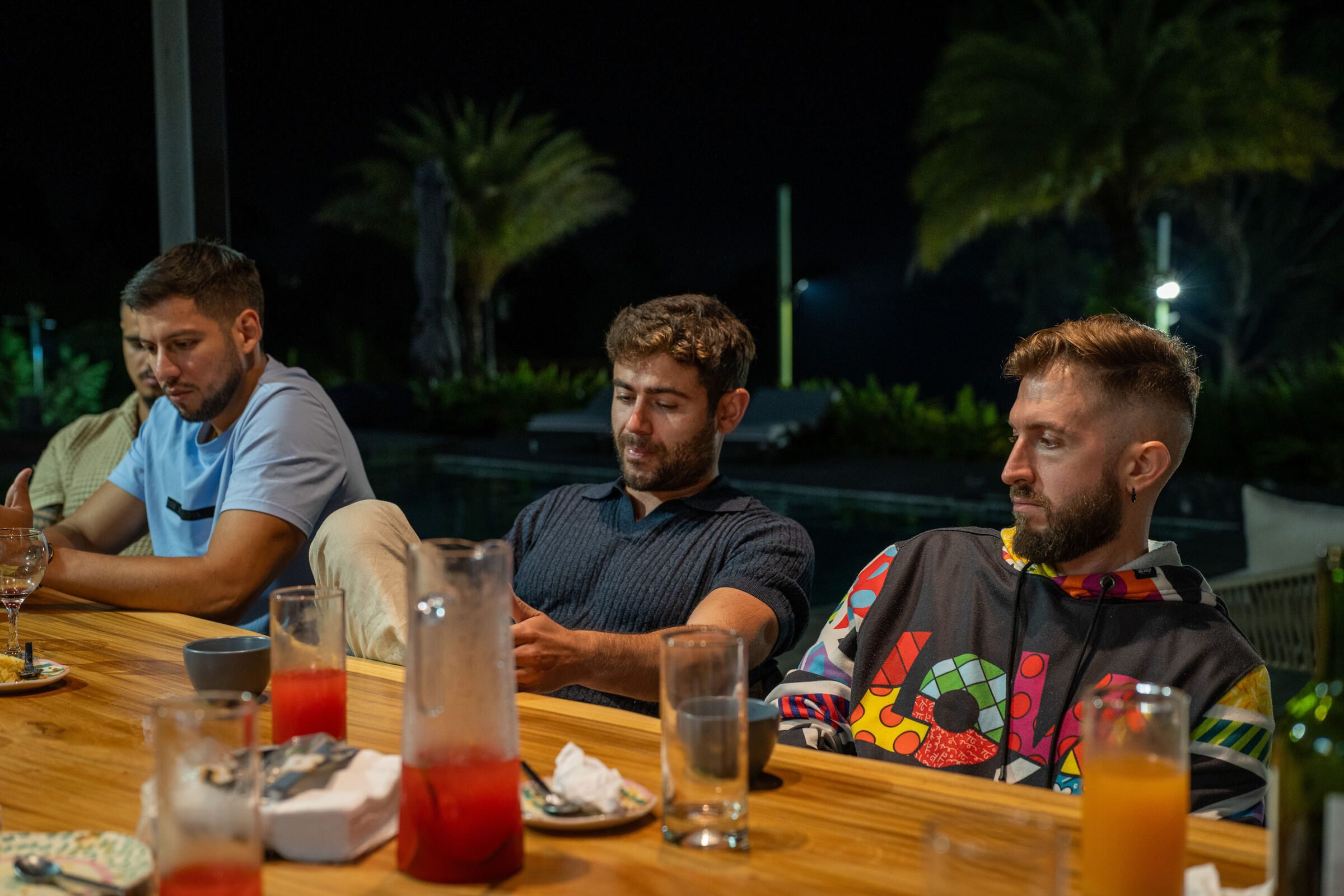 Three Founders Reset attendees laughing at the dinner table at night.