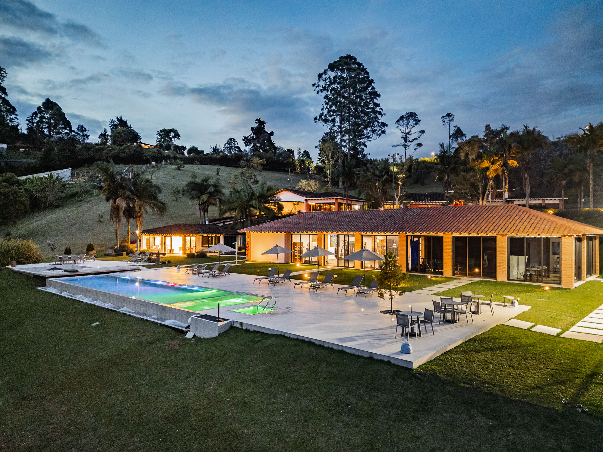The main house and pool at Mountains of Hope lit at dusk.
