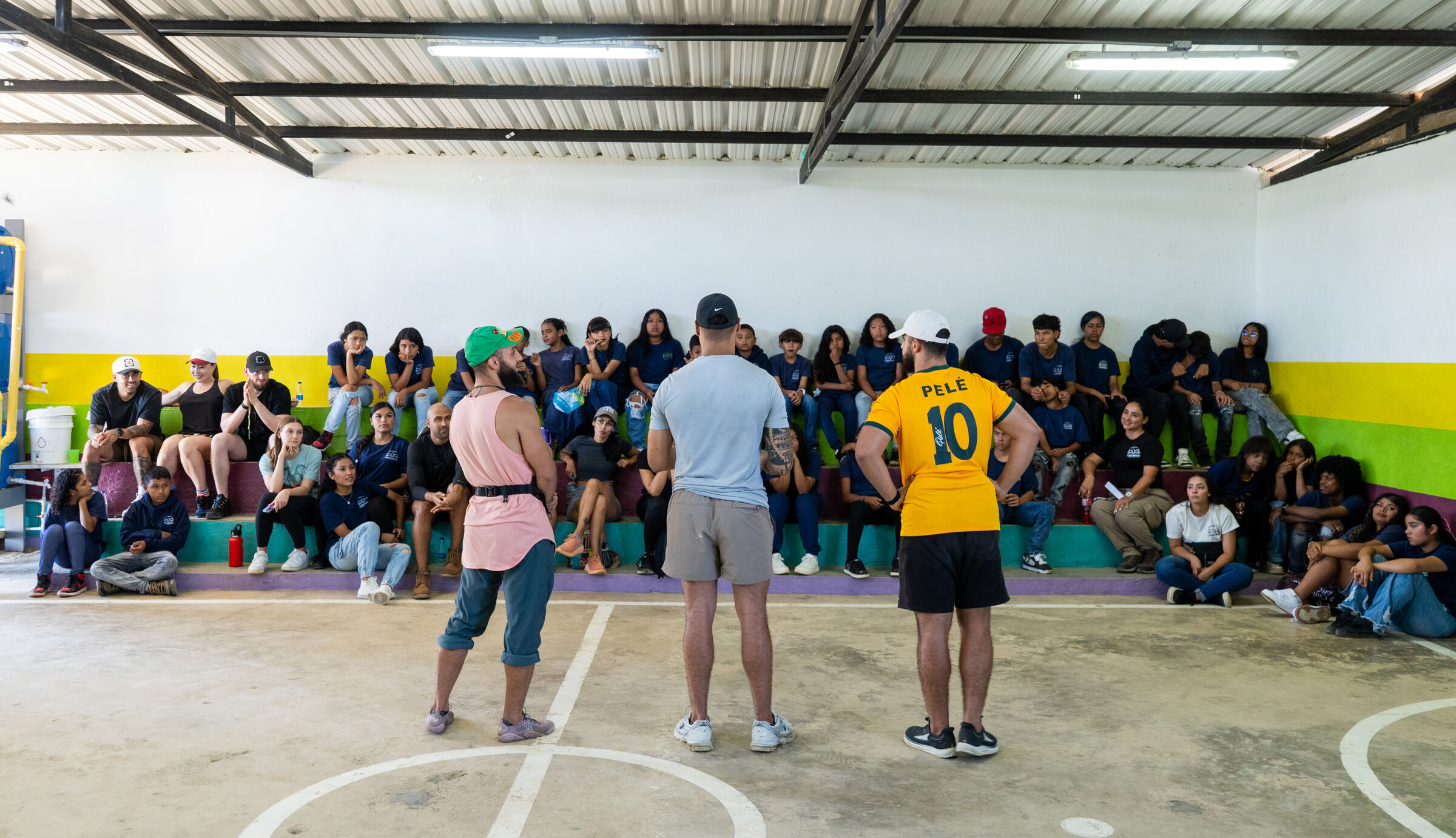A large group of volunteers and children gathered in a community hall with Fundación Conciencia.