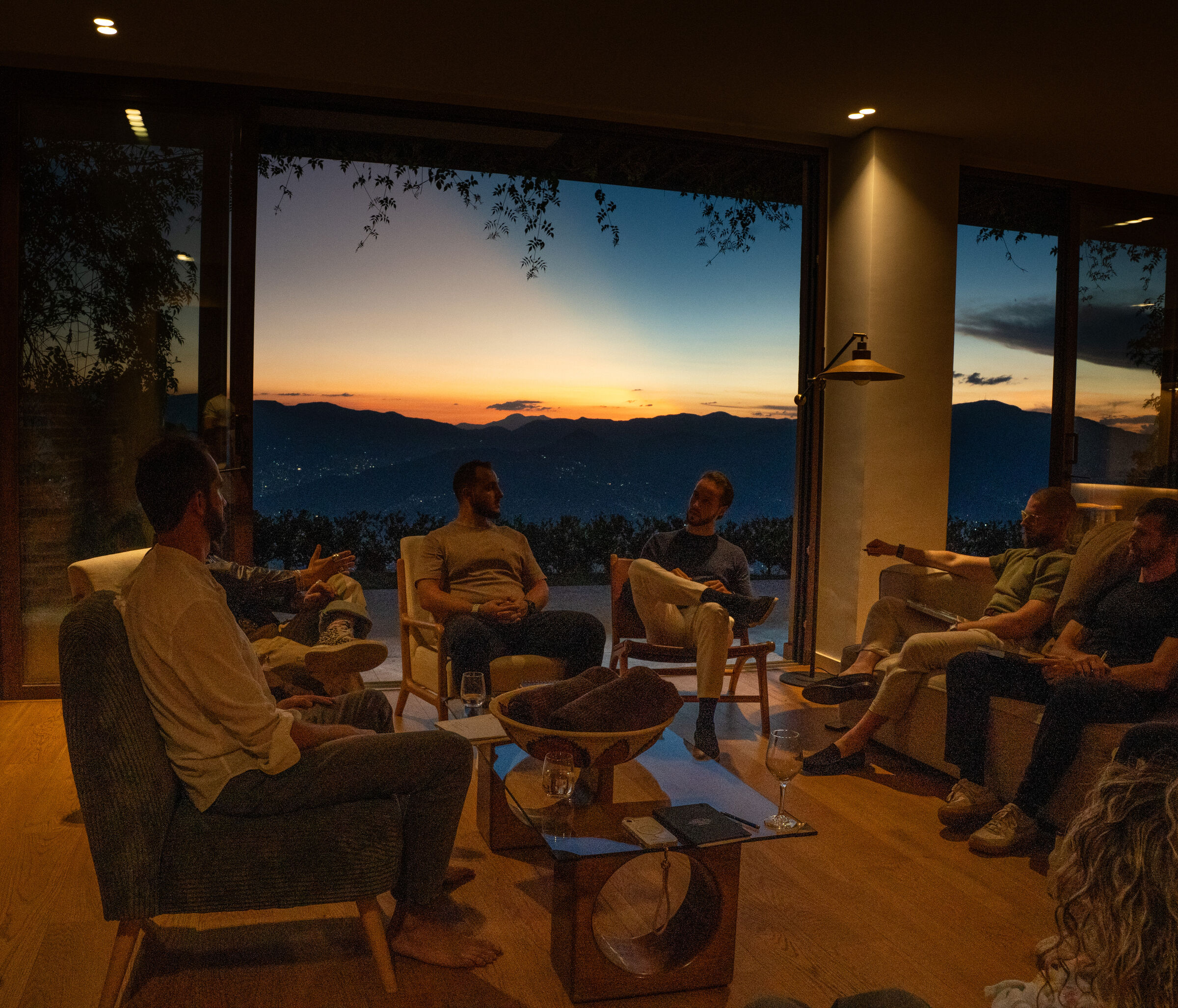 Founders in armchairs facing a window at sunset during THE ONE's Letting Go gathering.