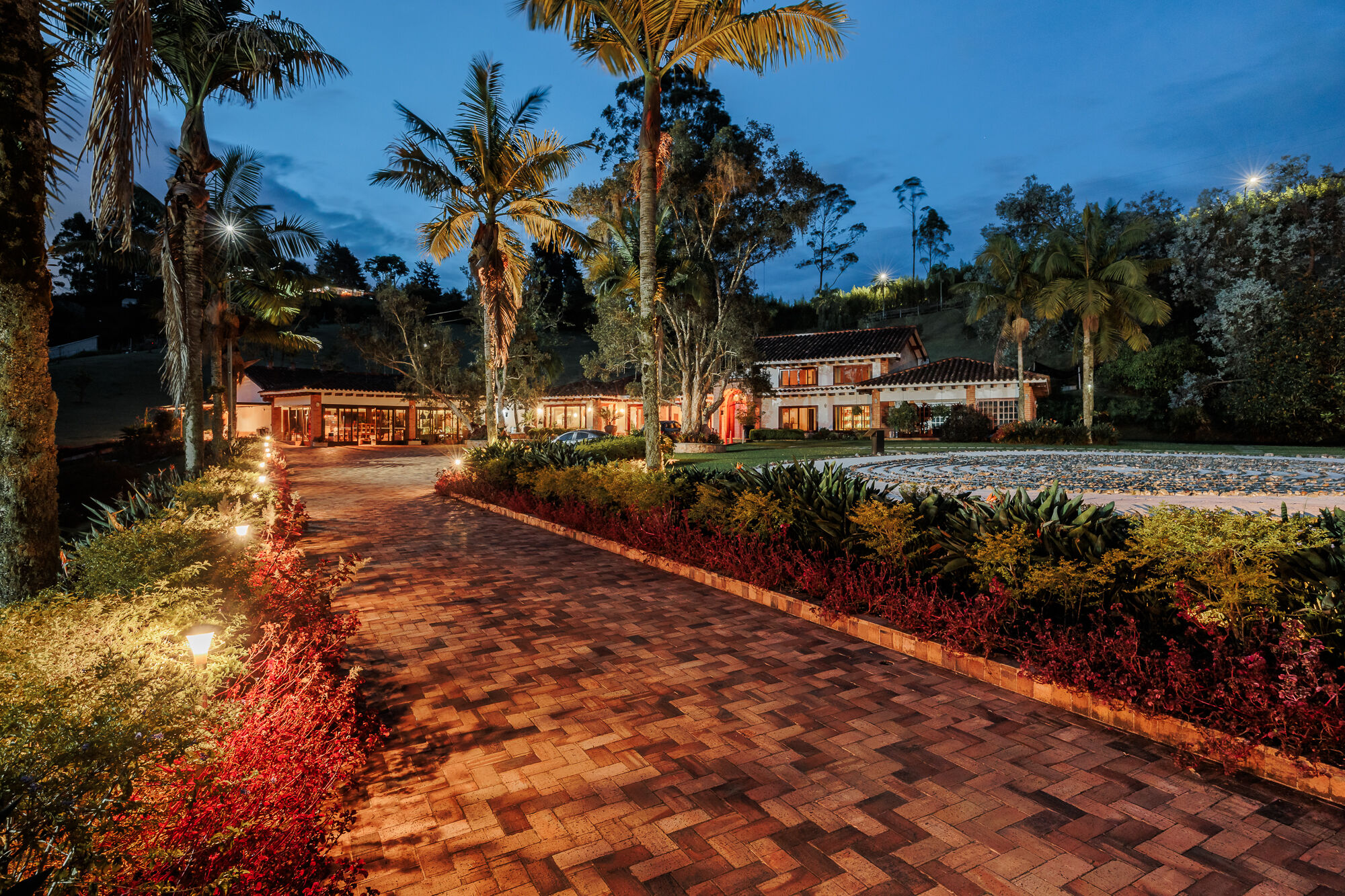 A brick path lit at blue hour leading to the main house at Mountains of Hope.