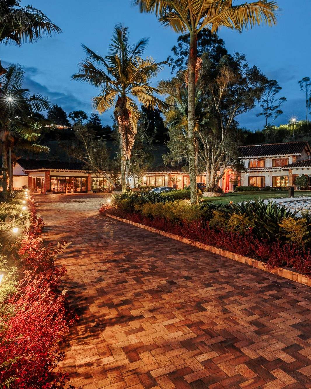 The lit brick path to the main house at dusk.