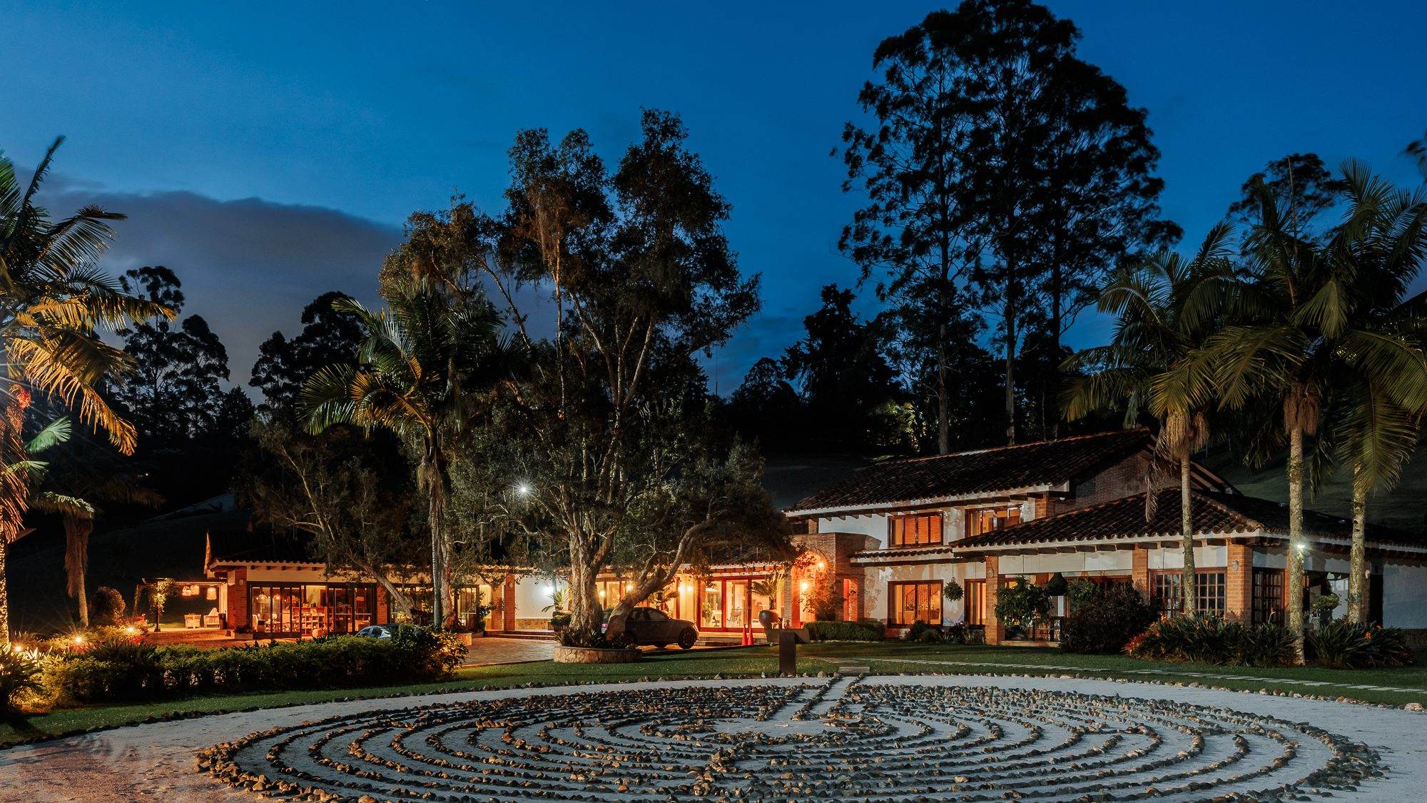 The main house at Mountains of Hope at blue hour, with the labyrinth in the foreground.