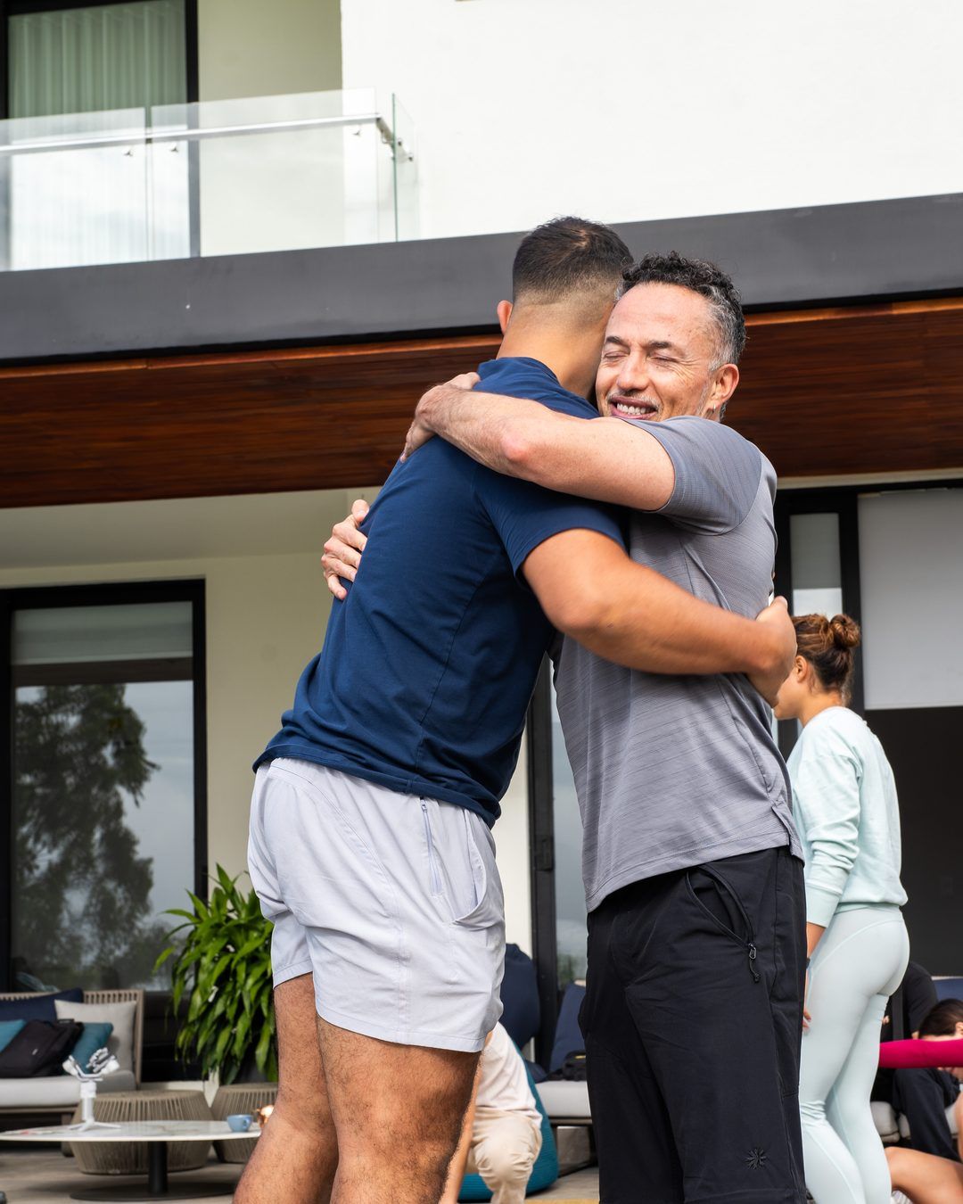 Two Founders Reset attendees embracing on the terrace.
