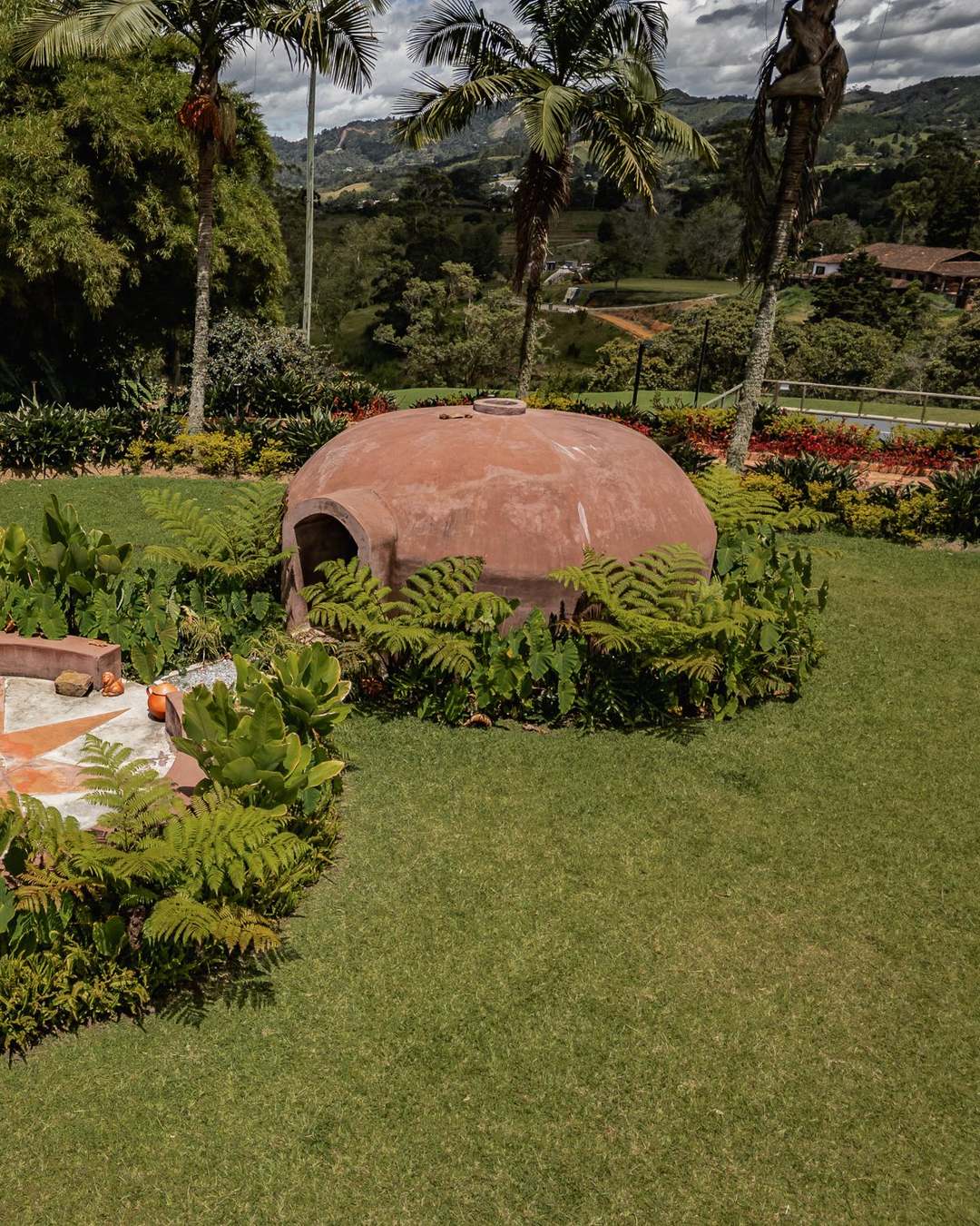 The domed temazcal beside its star-patterned ceremonial circle on the lawn at Mountains of Hope.