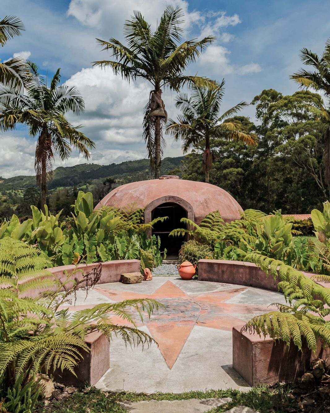 The domed temazcal at Mountains of Hope, its ceremonial circle framed by palms and ferns.
