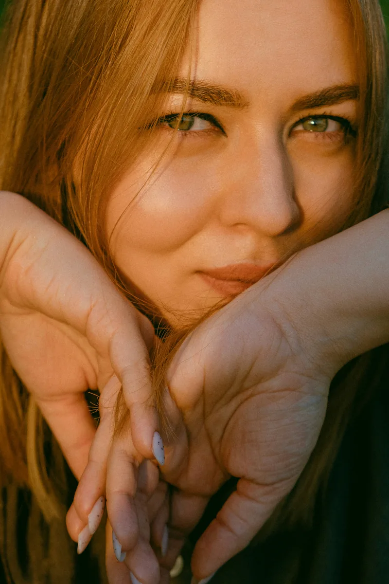 Patient with auburn hair resting her chin on her hands