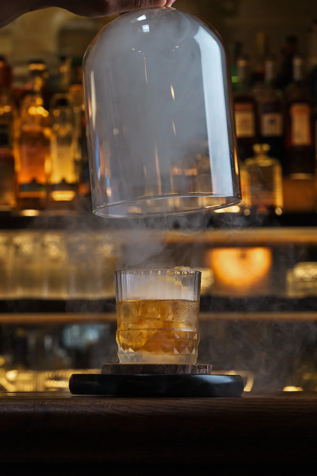A smoked cocktail revealed from under a glass cloche, from Ruchira Neotia's drinks list for Darjeeling Express