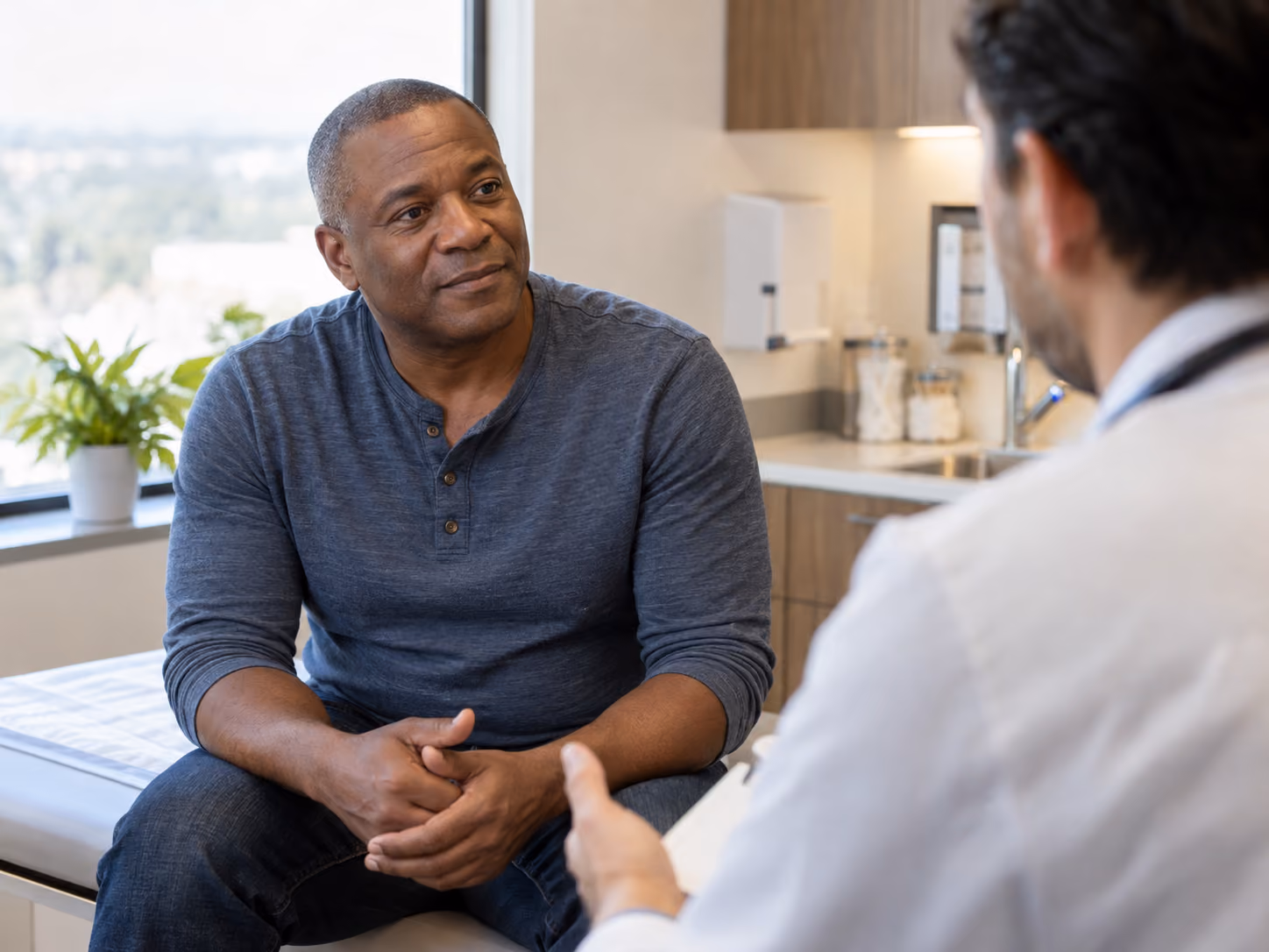 Man discussing his health with a clinician during a medical consultation.