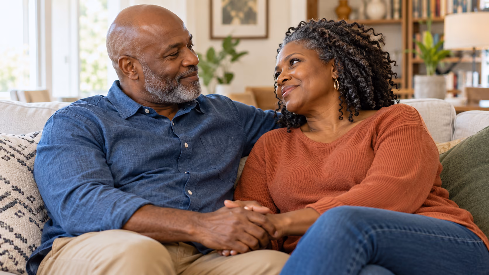 Older couple sitting closely together on a sofa.