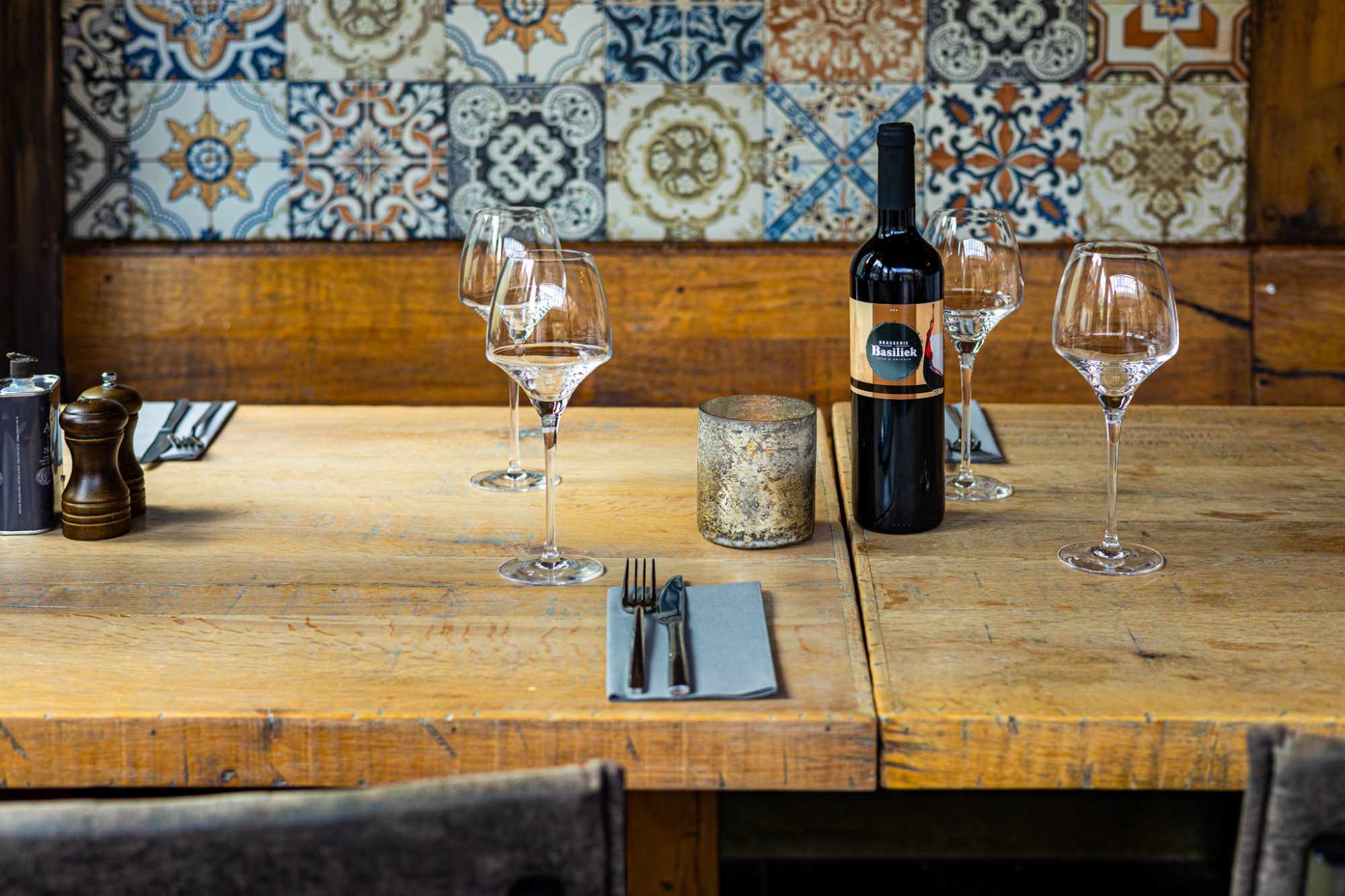 Gedekte tafel met wijnglazen en een fles wijn