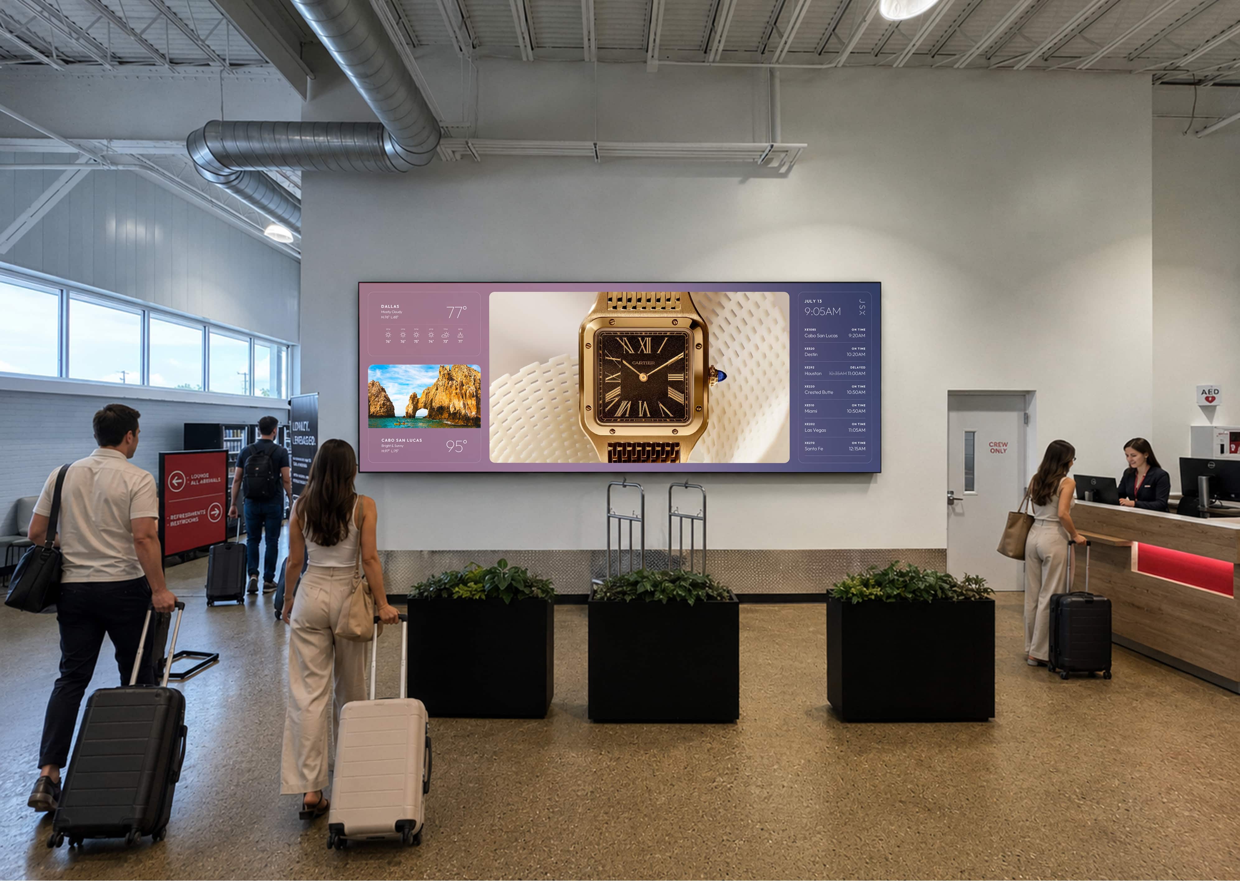 Travelers passing a large digital display in a terminal