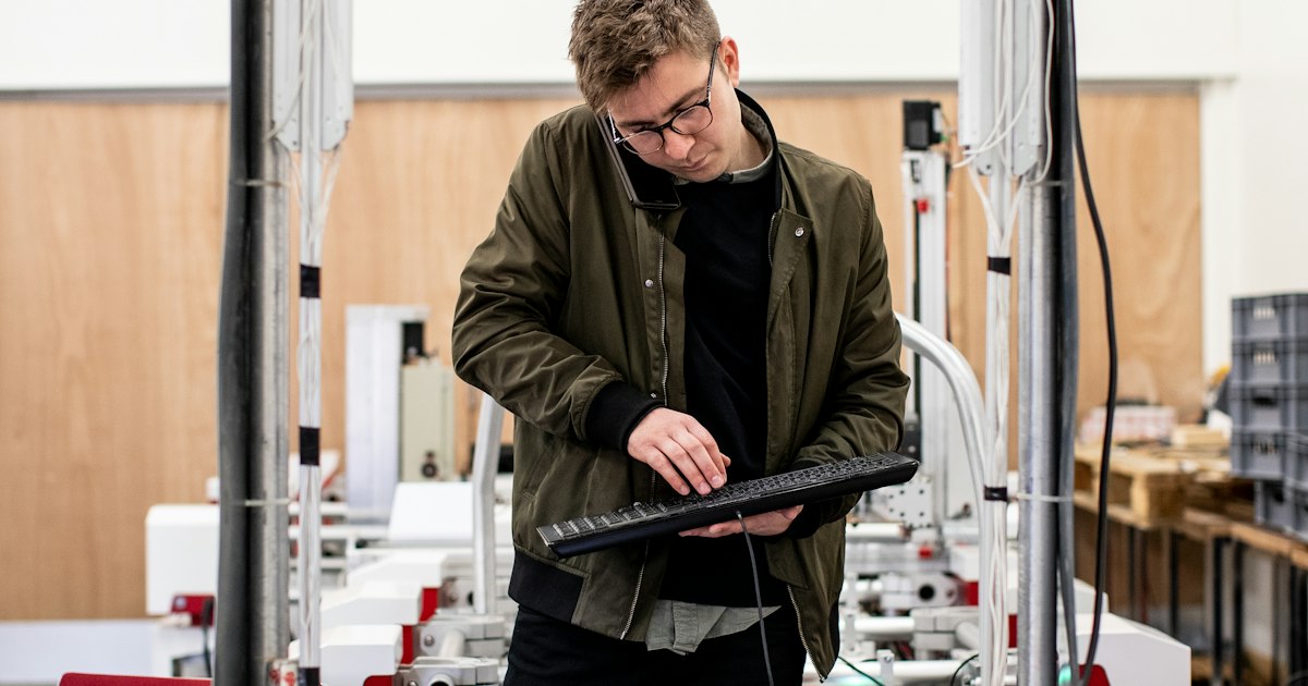 Ingenieur arbeitet an einer Maschine in einer Werkhalle