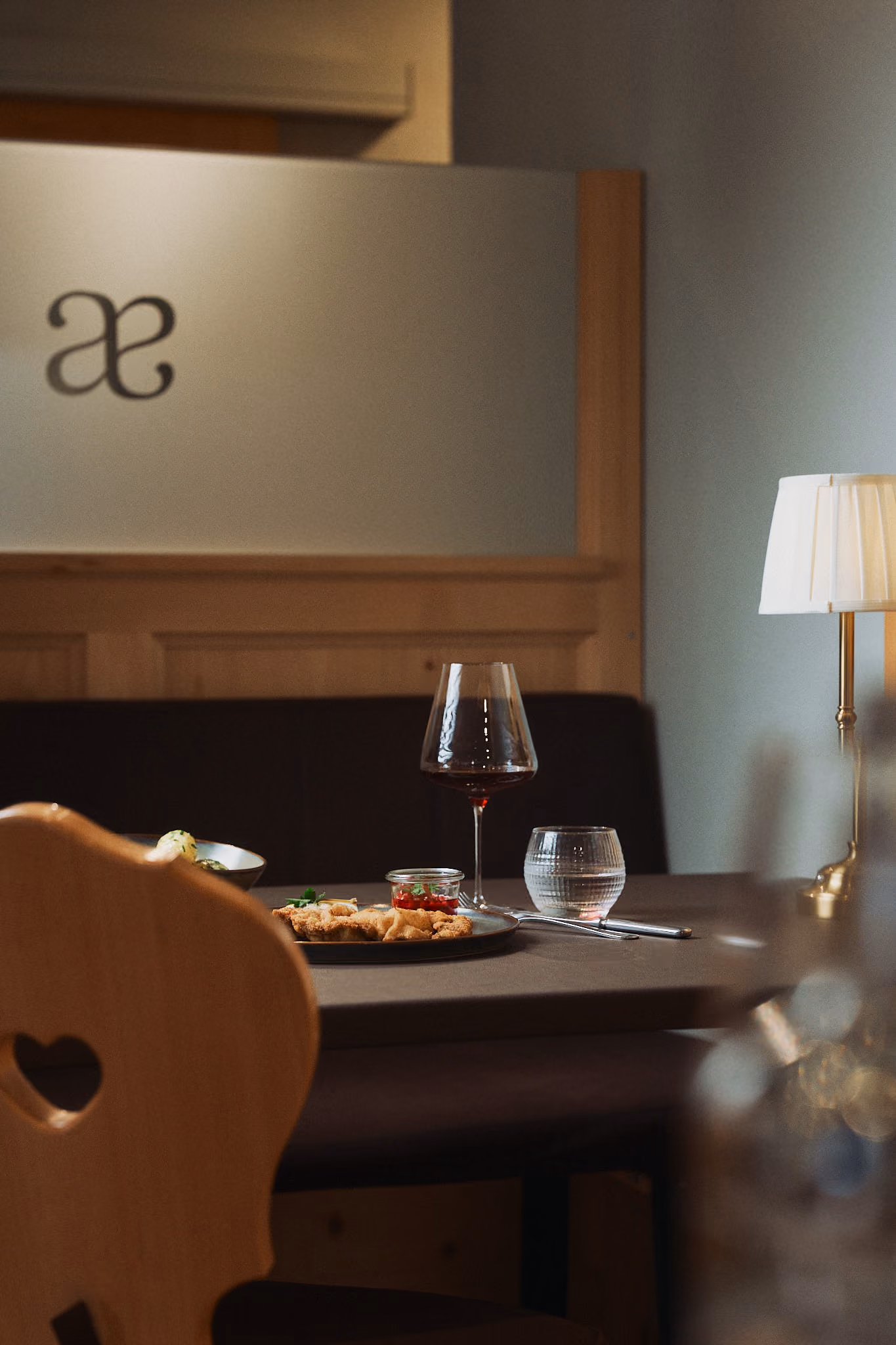 Gemütliche Bündner Gasstube. Wein und Essen auf dem Tisch.