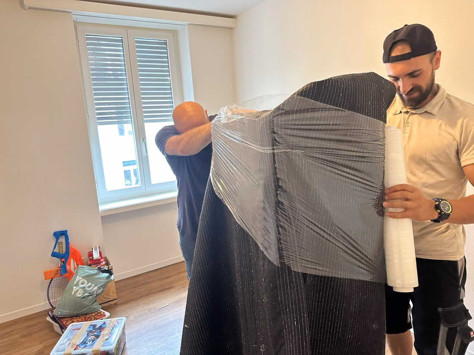 Zügelteam von Züri Umzug 24 verpackt ein Möbelstück sorgfältig in Folie