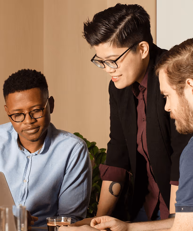 Three people collaborating on a laptop