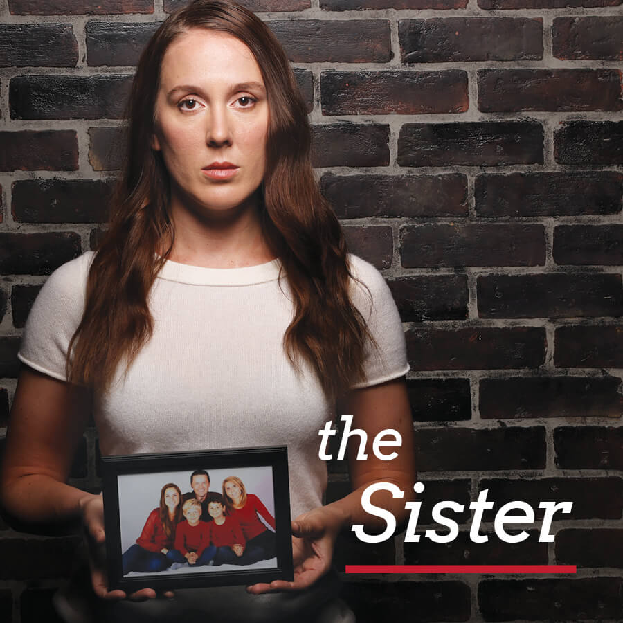 A woman holding a photograph of her brother's family