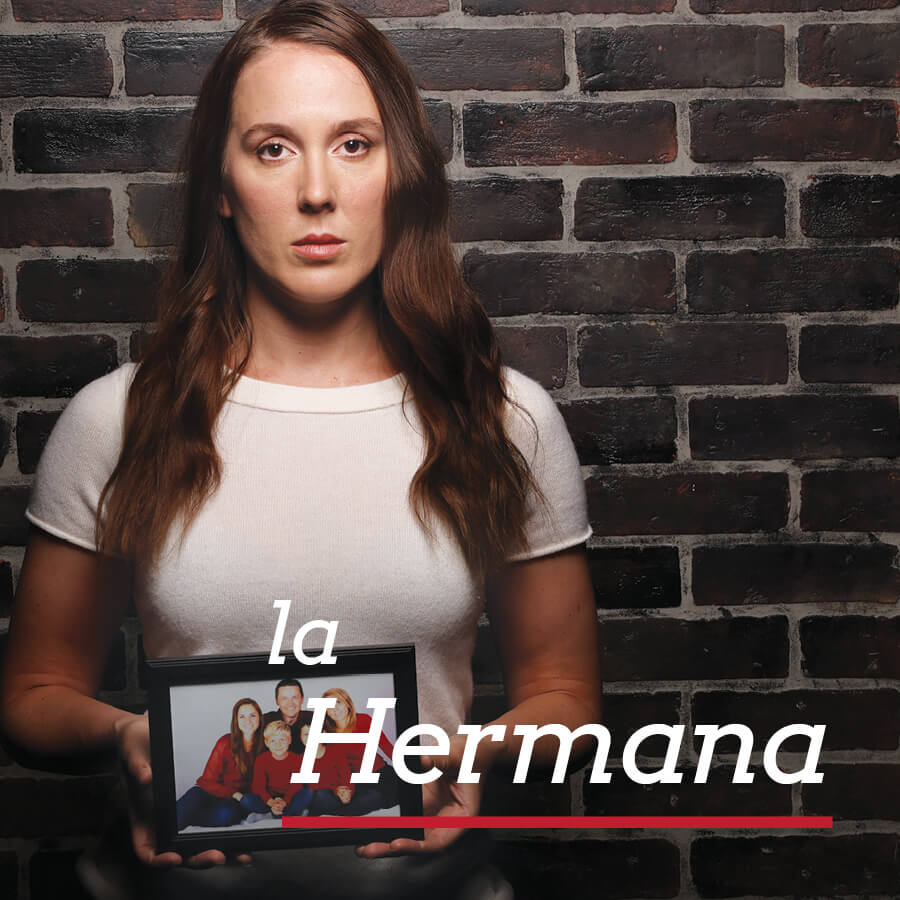Una mujer sosteniendo una foto de la familia de su hermano