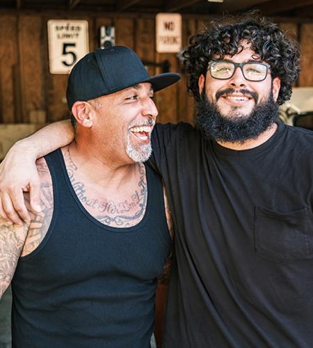 Dos jóvenes conversando, sentados al aire libre