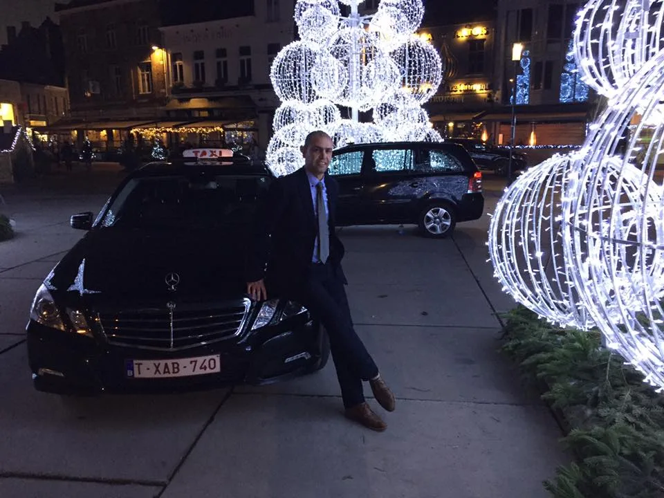 Chauffeur van Taxi Roeselare naast zijn wagen in het centrum