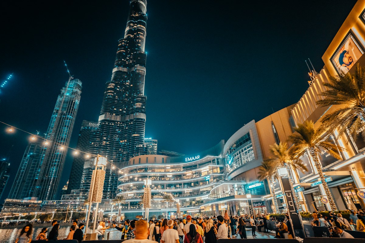 Crowds in Downtown Dubai at night beneath the Burj Khalifa
