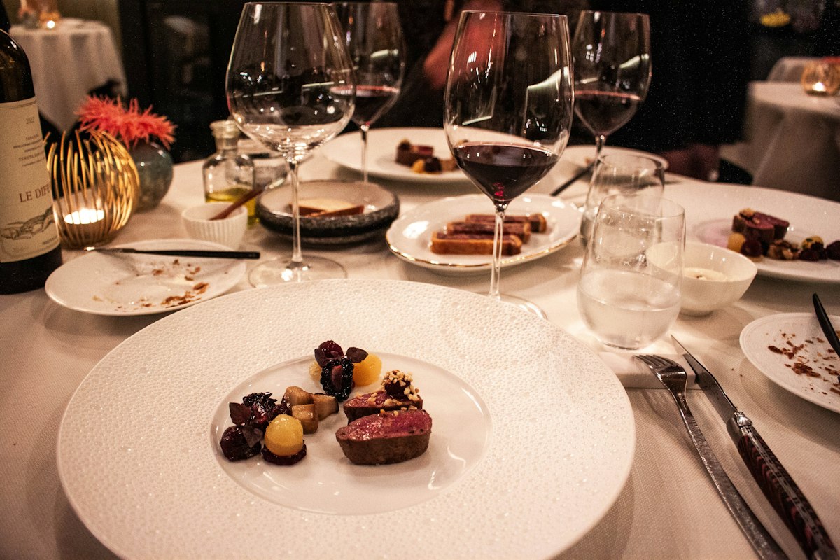 A fine-dining table set with wine and tasting plates