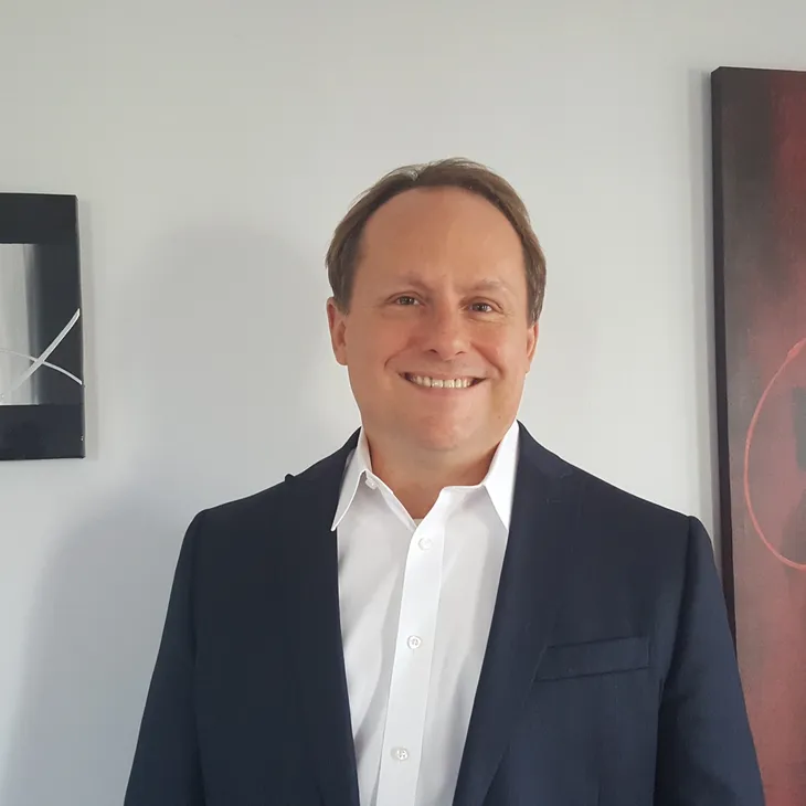 Dave VanEpps smiling in a navy jacket and white shirt.
