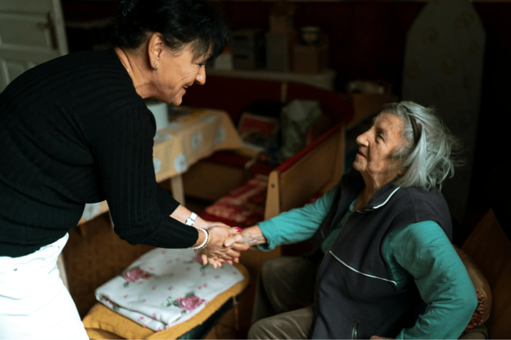  Elderly Caregiver Shaking Hands with Senior Woman
