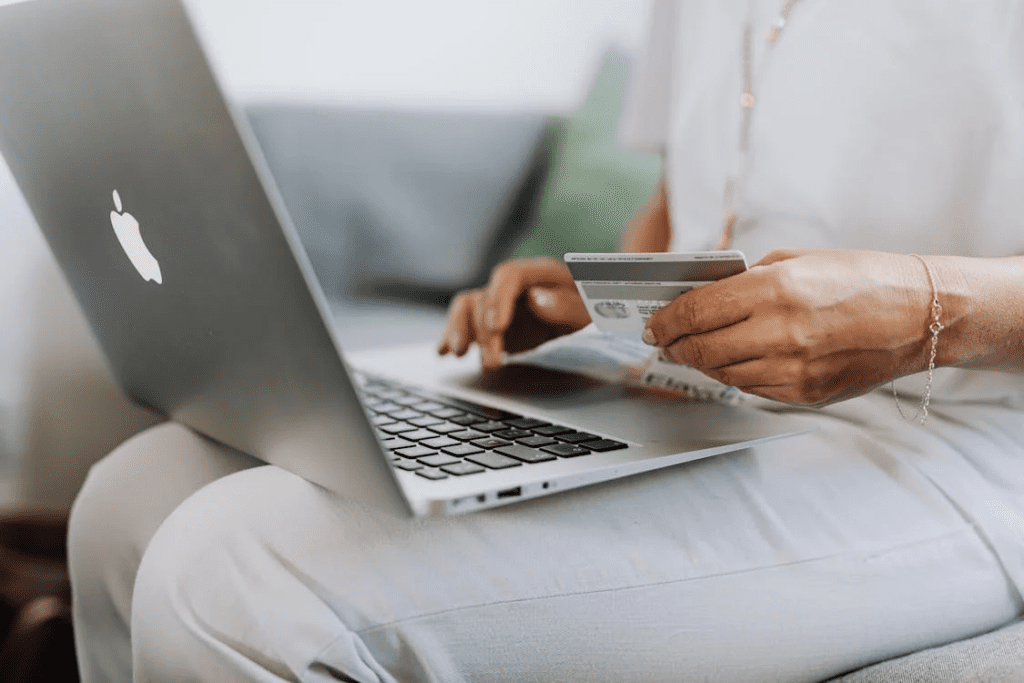 a person using macbook and credit card