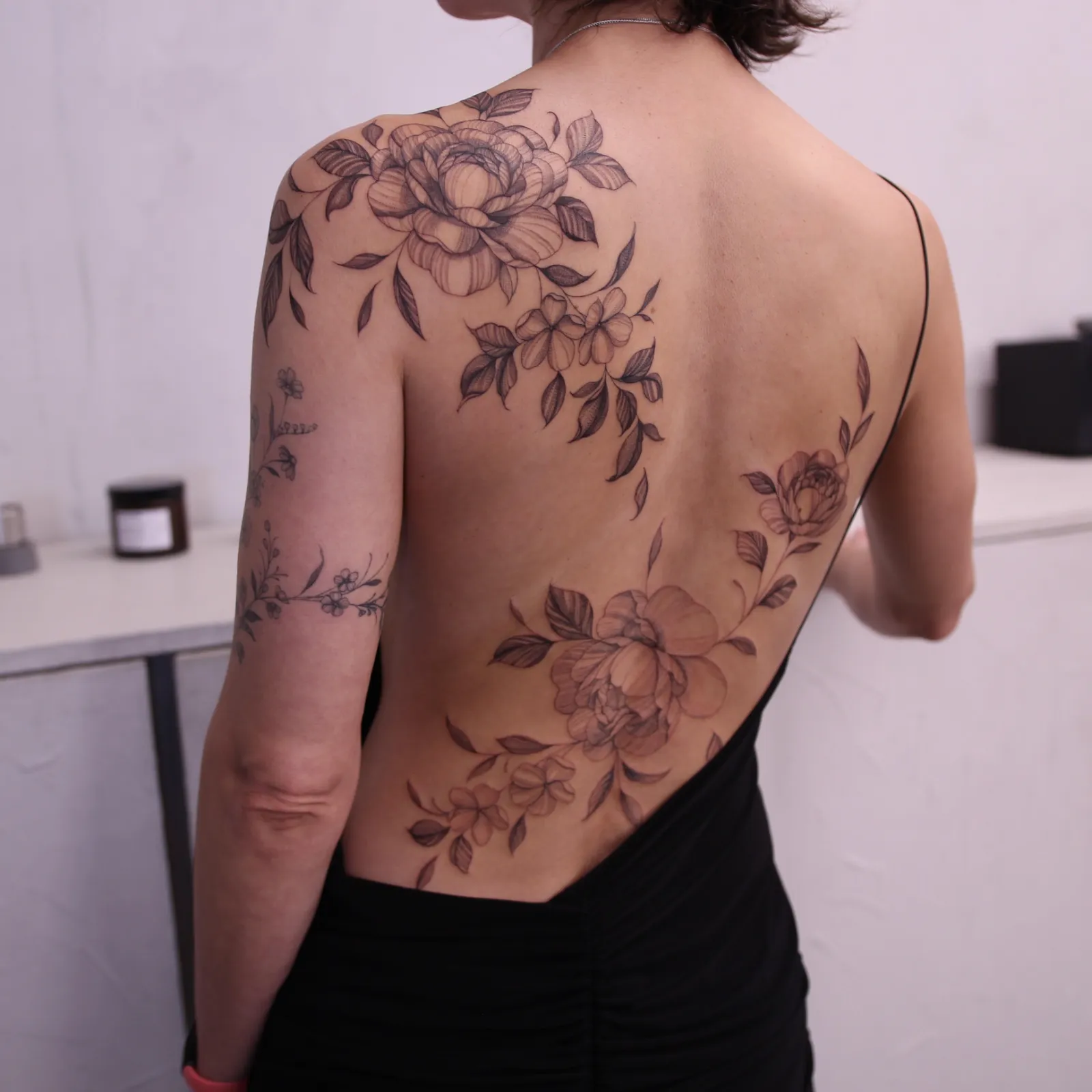 Fine line floral back piece by Charlotte Glatt at SANS PATRIE/ STUDIO