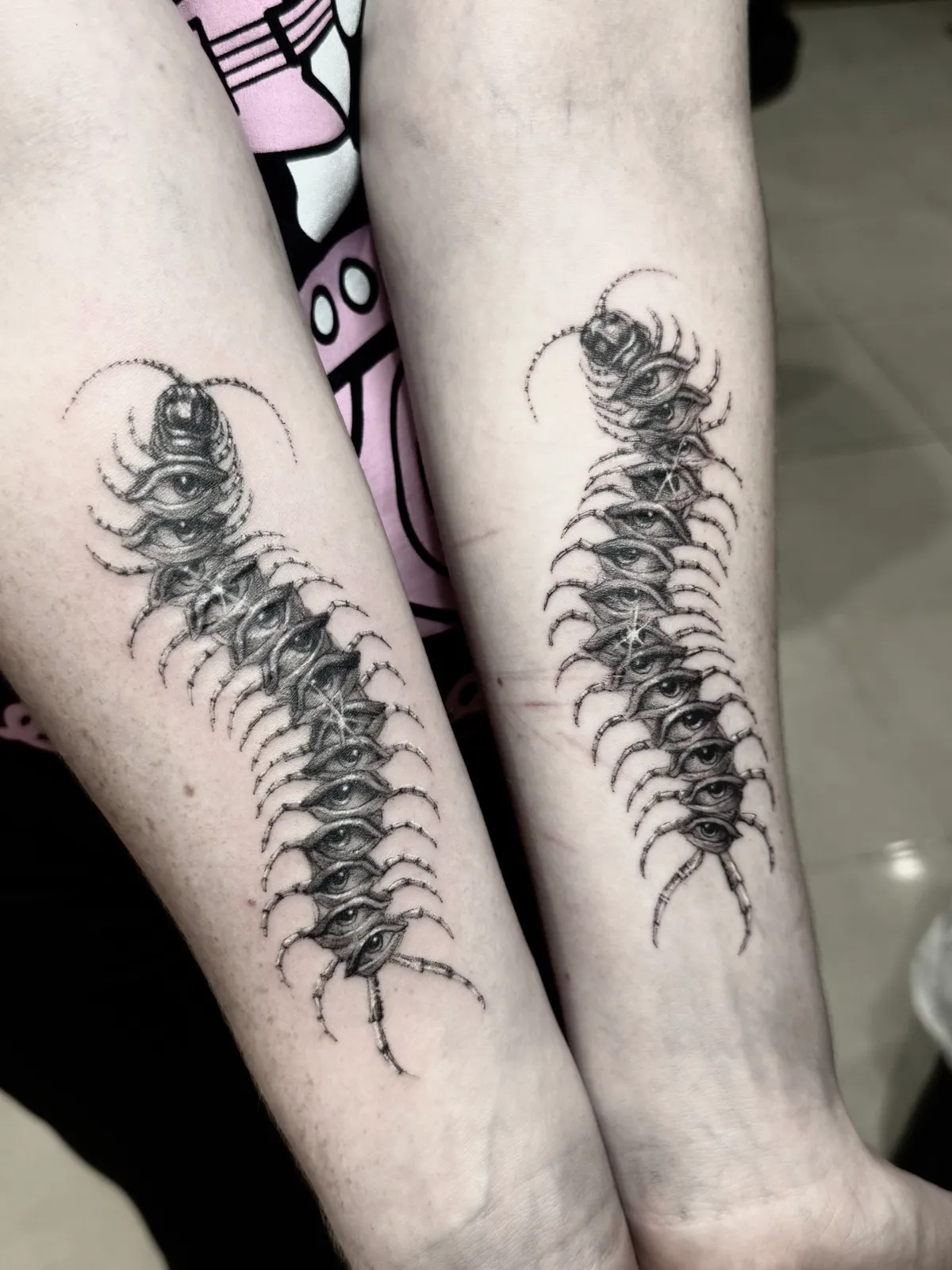 Matching blackwork centipede forearm tattoos by Sora at SANS PATRIE/ STUDIO