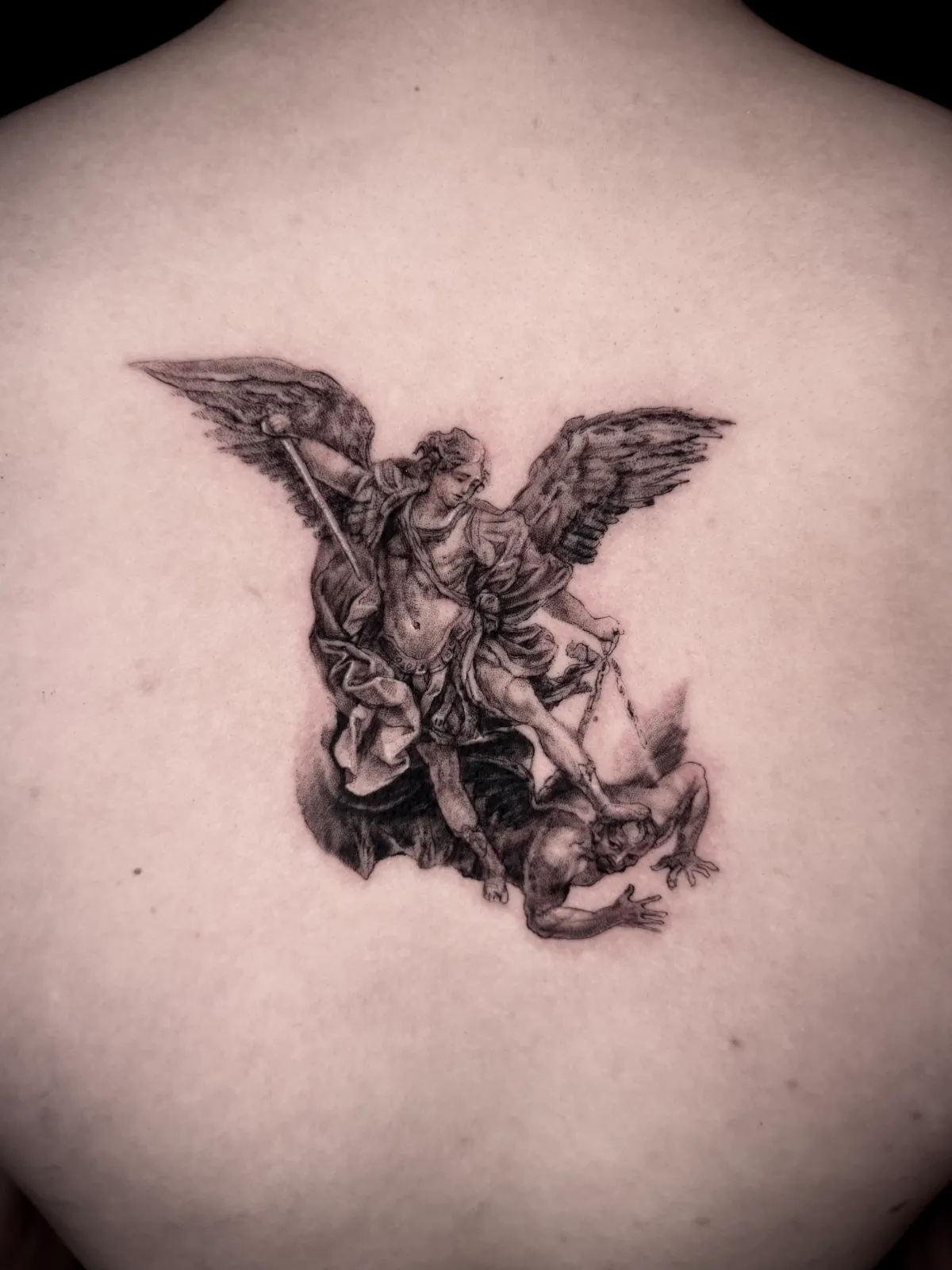 Black and grey archangel back tattoo in a classical style by Sora at SANS PATRIE/ STUDIO