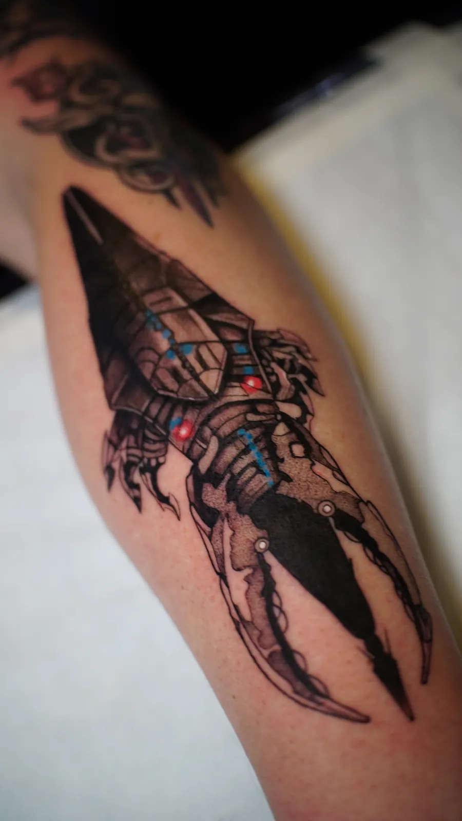 Sci-fi spaceship forearm tattoo with colour details by Draco at SANS PATRIE/ STUDIO