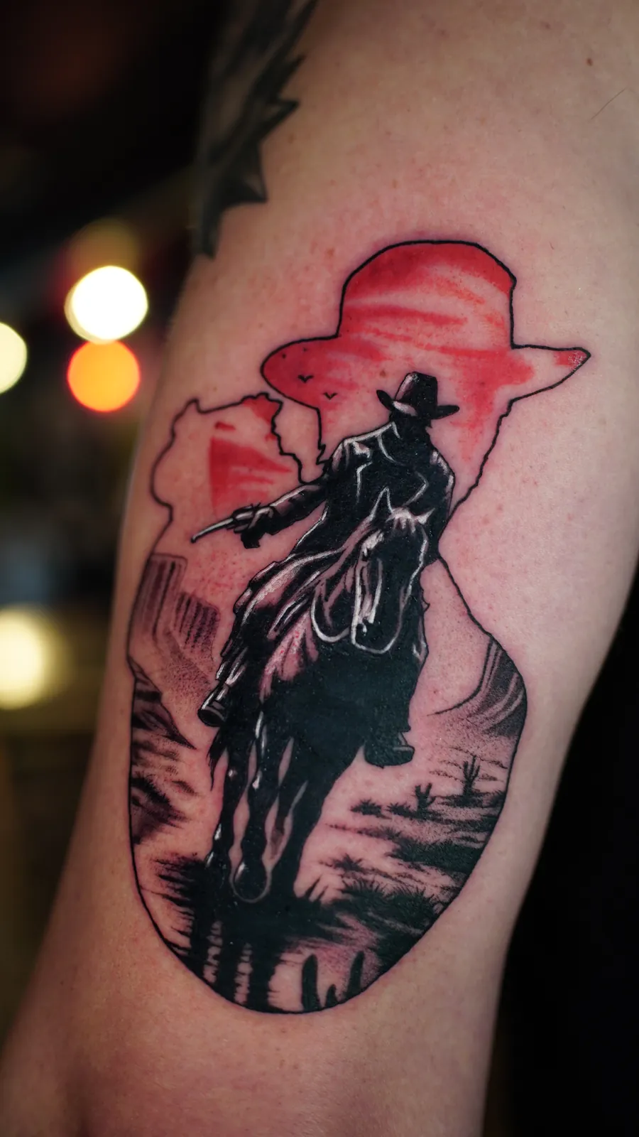 Red and black cowboy on horseback silhouette tattoo by Draco at SANS PATRIE/ STUDIO