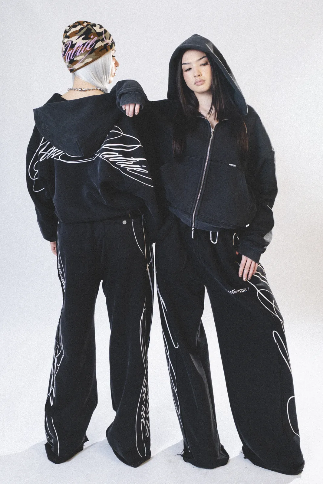 Two models in black Von Dutch tracksuits
