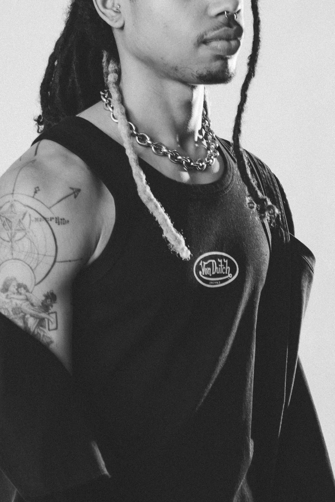 Close-up of a tattooed model in a black Von Dutch vest