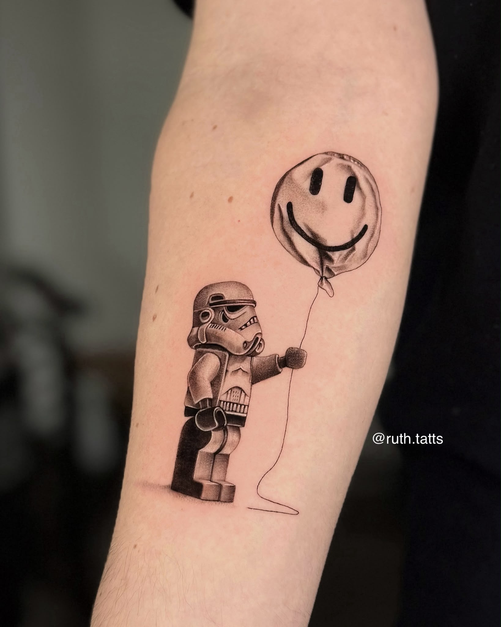 Micro-realism minifigure trooper with smiley balloon tattoo by Ruth Bitton at SANS PATRIE/ STUDIO