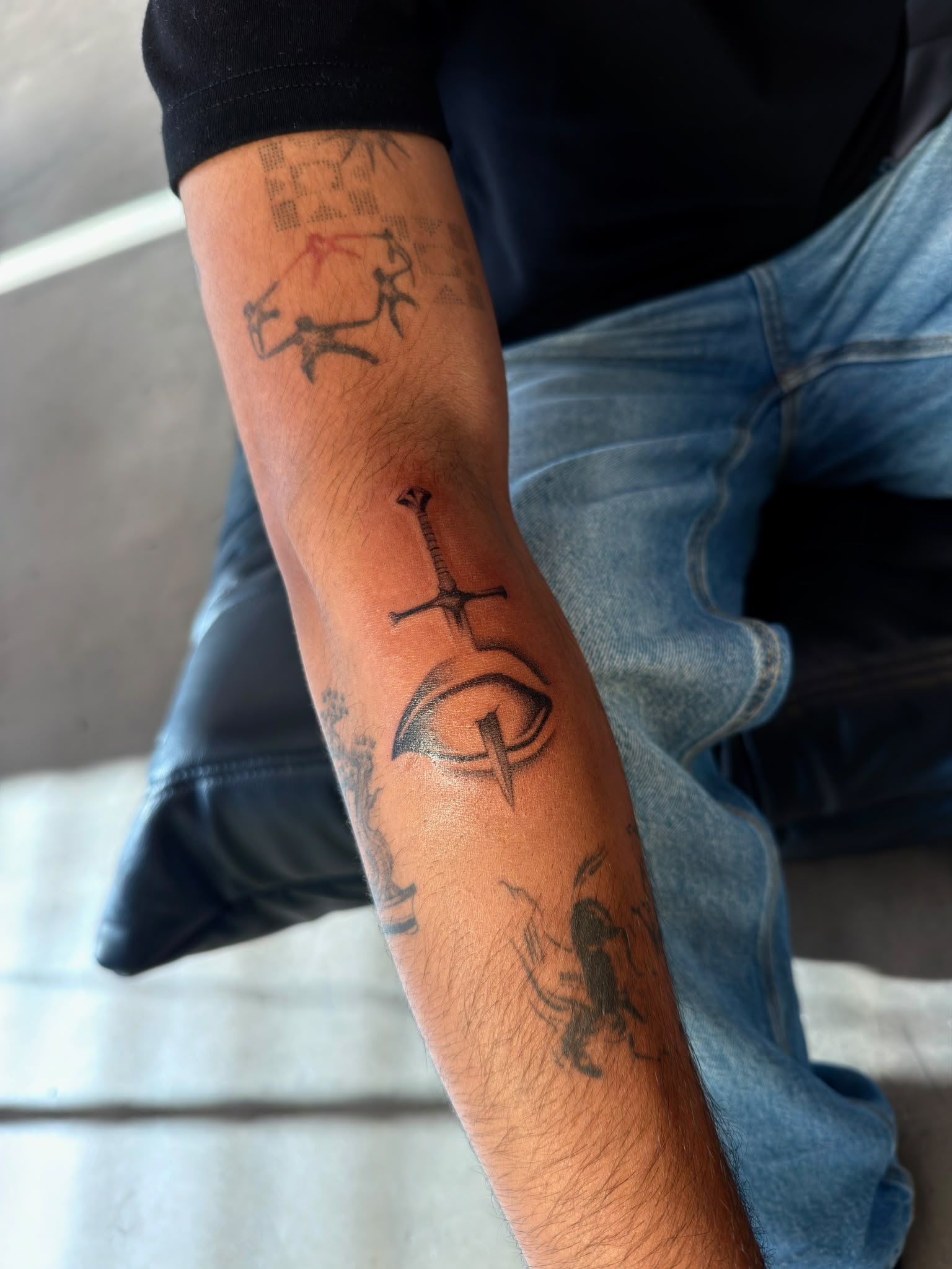 Sword and eye forearm tattoo by Tyrese Gilzene at SANS PATRIE/ STUDIO