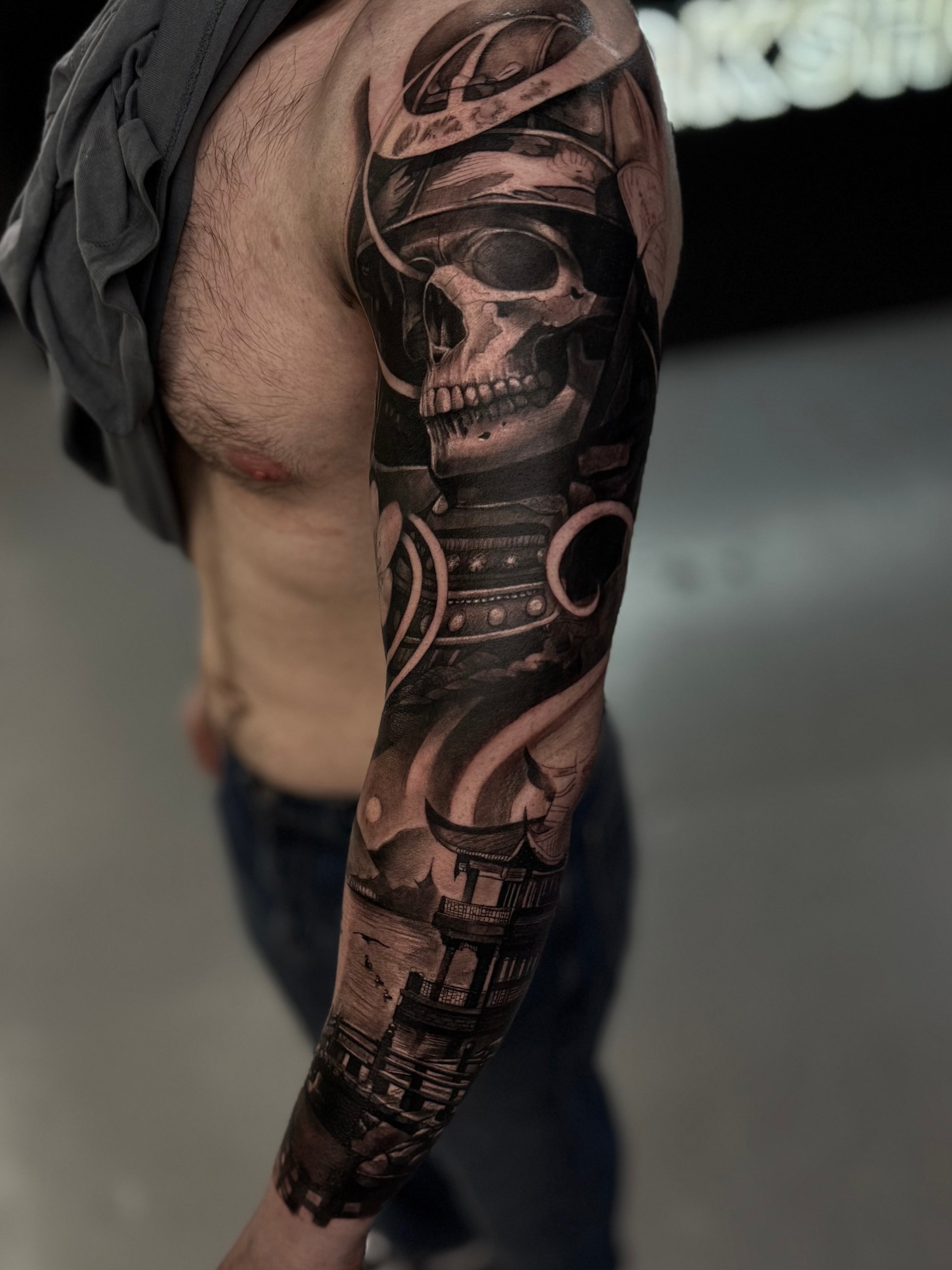 Black and grey samurai skull and temple full sleeve tattoo by Kayley Laroche at SANS PATRIE/ STUDIO