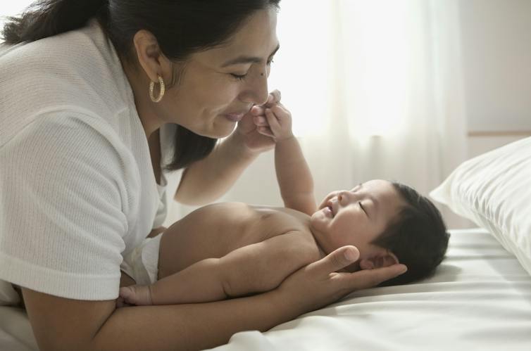 Mother lying with her son on a bed