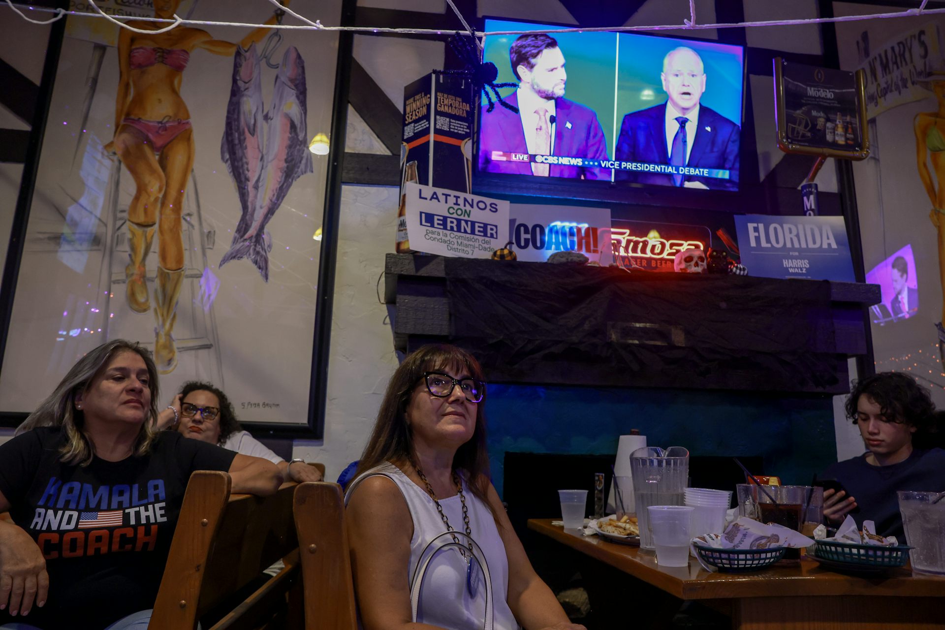 People at a restaurant watching the debate on a screen