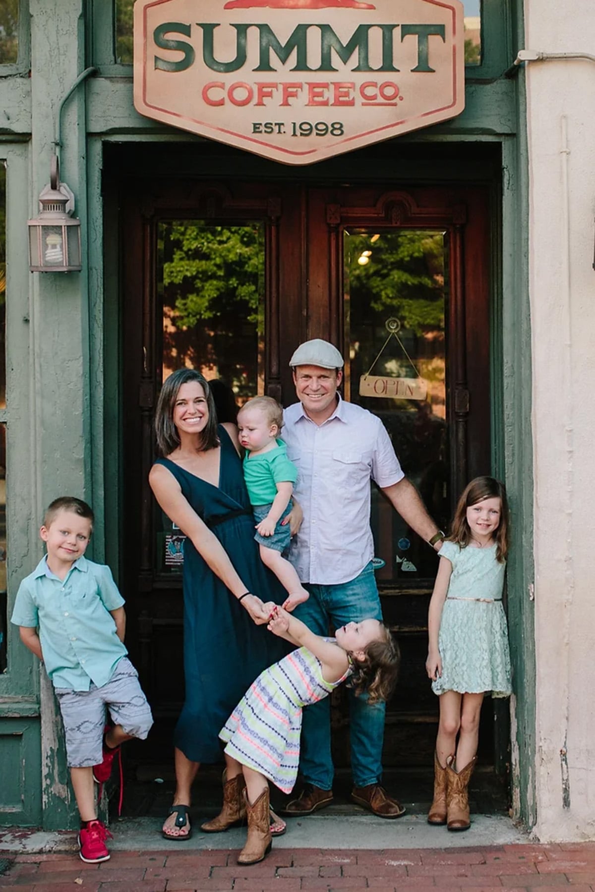Beth Helfrich stands outside a coffee shop with her husband and five children.