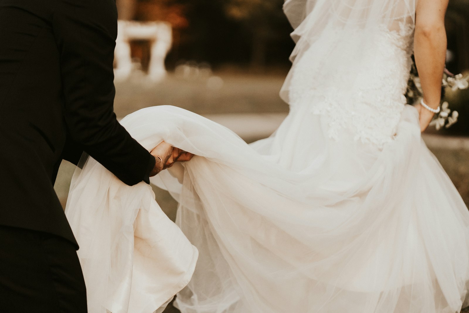 Man helping a bride with her wedding dress before the ceremony
