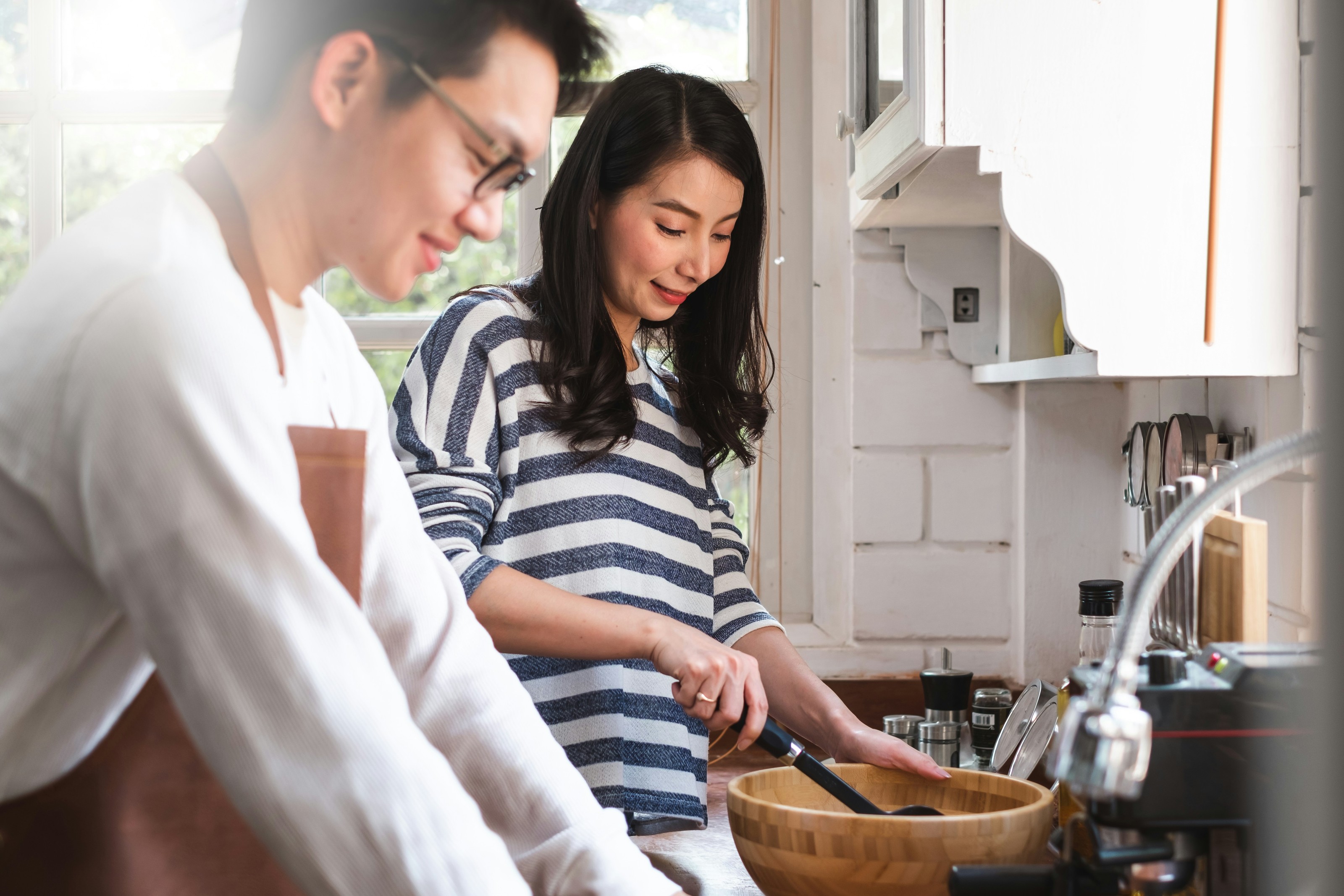 A couple cooking together at their kitchen counter