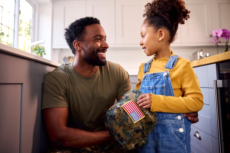 A father and daughter smiling together in the kitchen