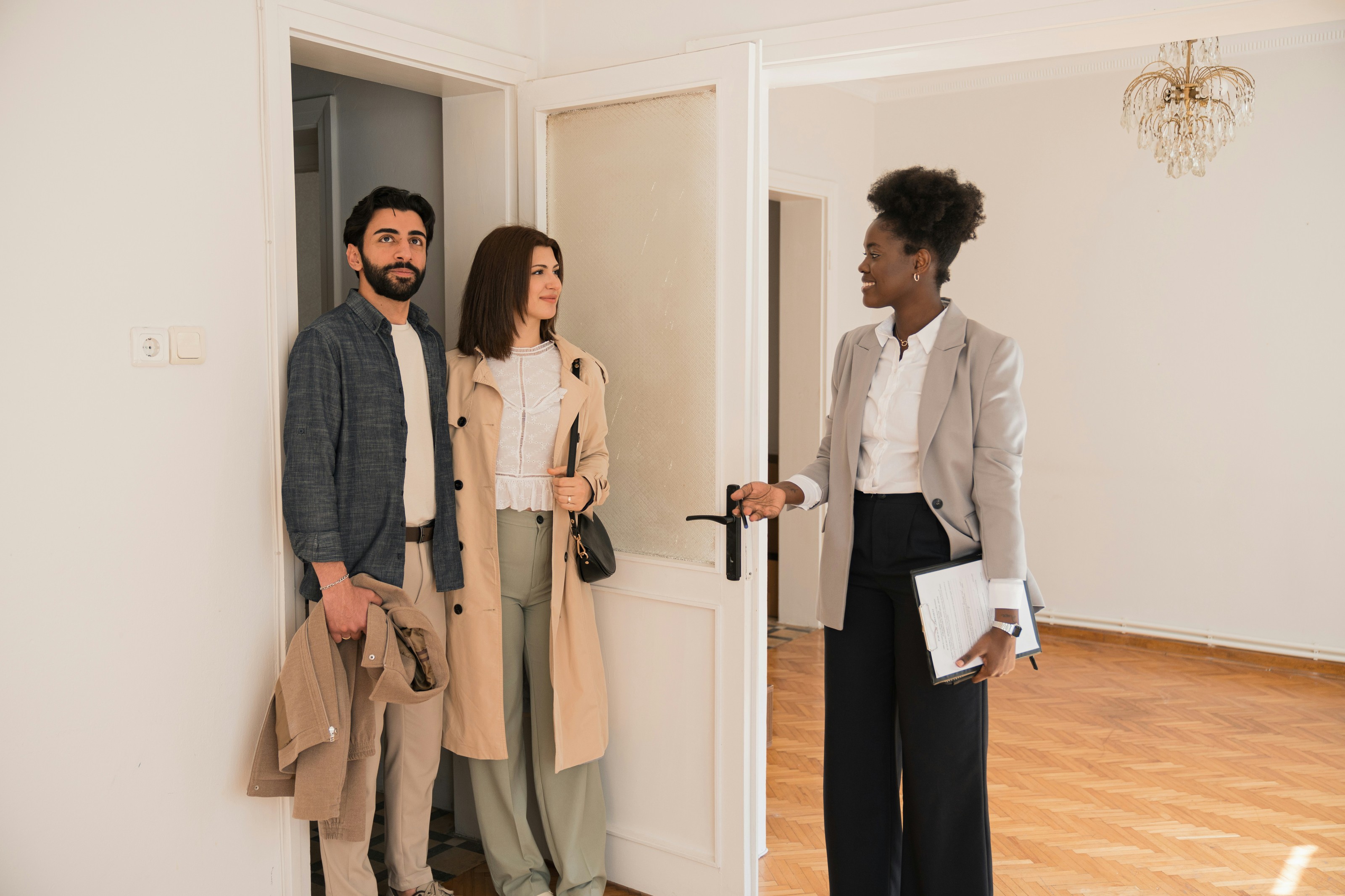 A real estate agent welcoming a couple into a home