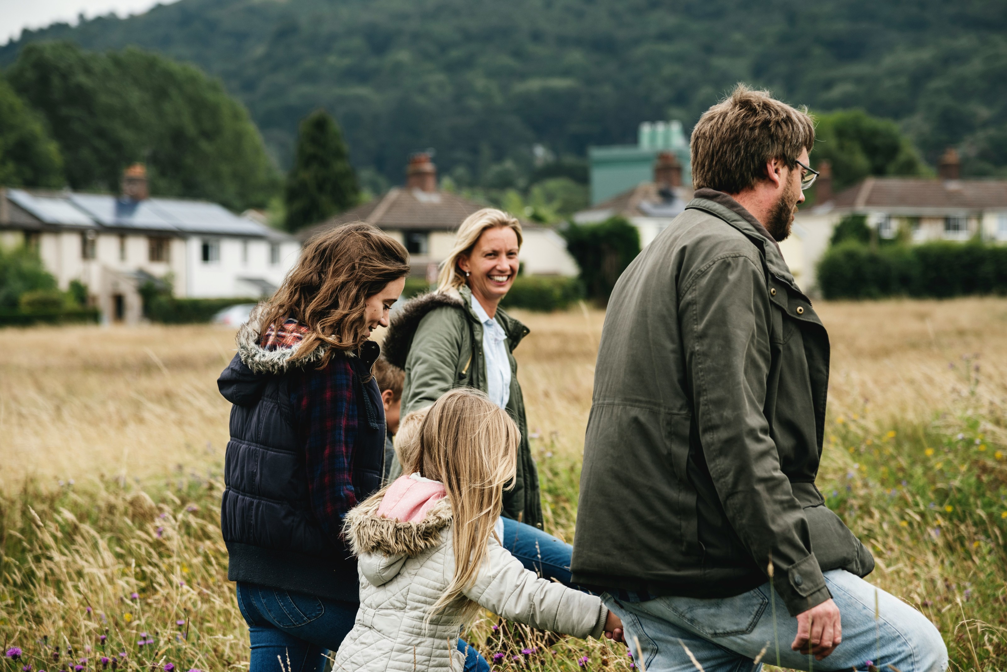 A family walking through a field near a small town